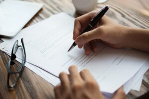 Person examining papers with glasses