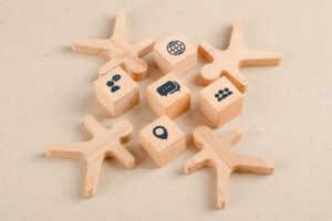 Social distancing concept with icons on wooden cubes, wooden figures on paper background high angle view.